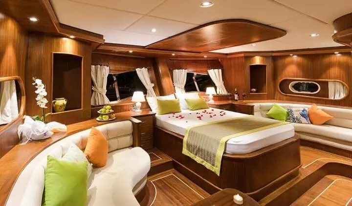 Master cabin with king bed, ensuite, warm wood interiors and bedside lamps