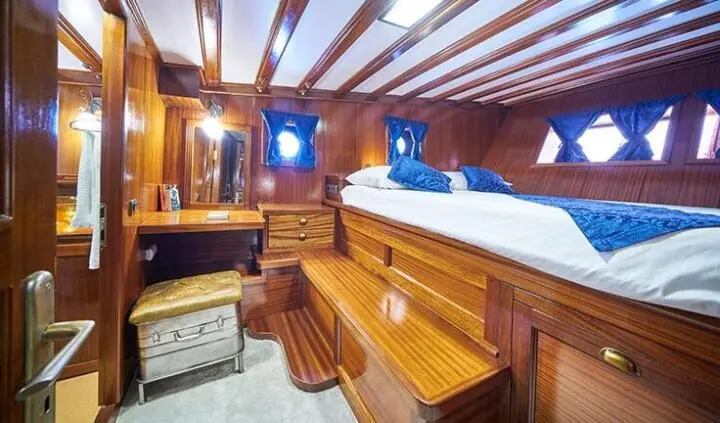 Stella Maris cabin with wooden dresser, large bed, and wood paneling
