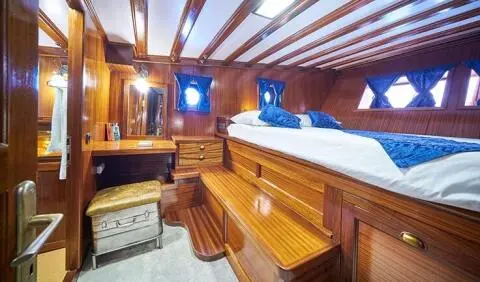 Stella Maris cabin with wooden dresser, large bed, and wood paneling