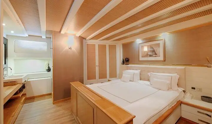 Cobra King yacht master cabin with large bed and wooden beams