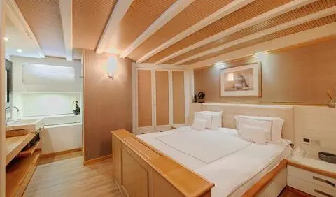 Cobra King yacht master cabin with large bed and wooden beams