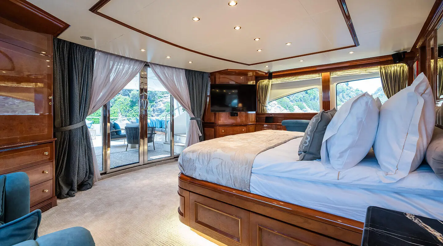 Amadea yacht luxury master cabin with large bed, wood panels, windows overlooking water