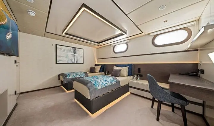 Master cabin with king bed, wood headboard, ensuite, and seating area on yacht Anima Maris