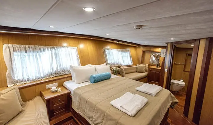 Master cabin on Kayhan 3 yacht with king bed, neutrally colored linens