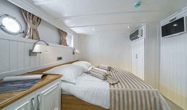 Maske master cabin with king bed, beige bedding, wood accents, ensuite door