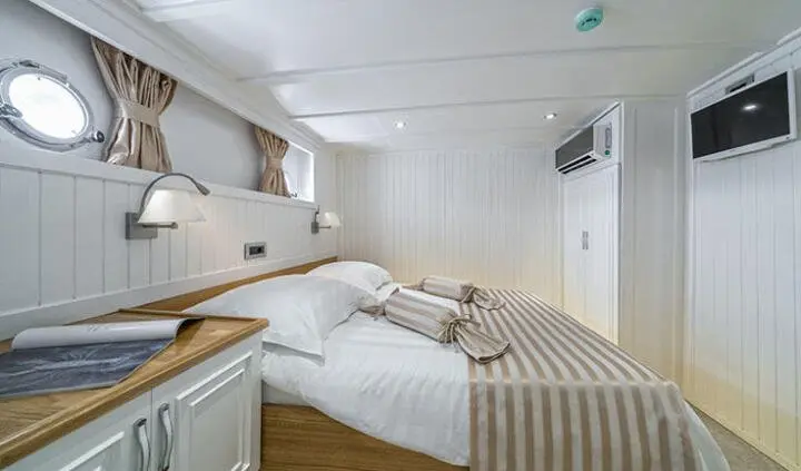 Maske master cabin with king bed, beige bedding, wood accents, ensuite door