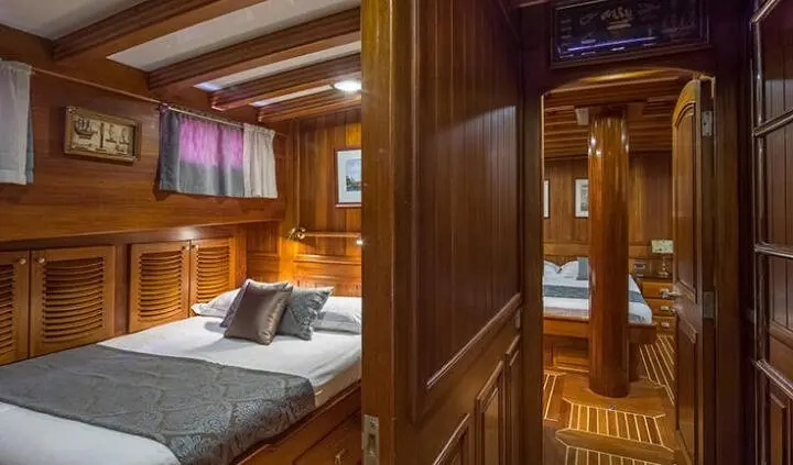Luxurious yacht master cabin with king bed, wooden panels, and ensuite hints