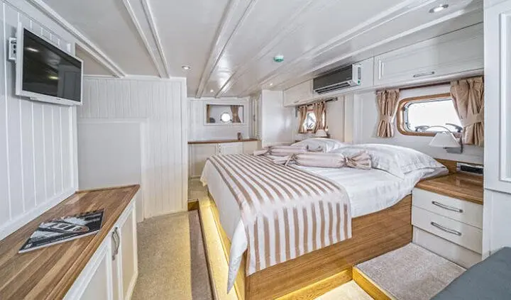 Master cabin with king bed, ensuite, wood accents, large portholes