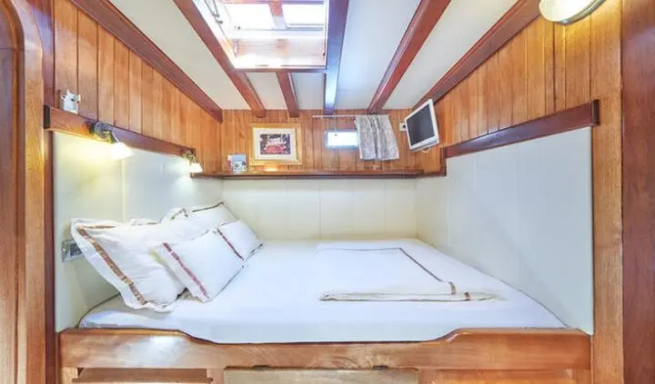 Luxurious cabin on a Gulet Libra yacht with white seating and wood paneling