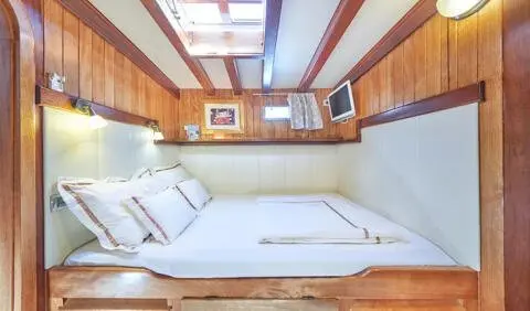 Luxurious cabin on a Gulet Libra yacht with white seating and wood paneling