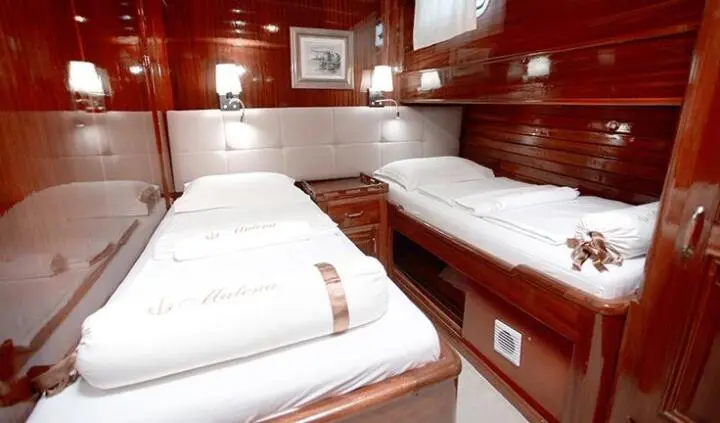 Interior of yacht Malena cabin with two twin beds and wood cabinetry