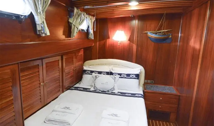 Ros Mare cabin interior with wooden panels and neatly made bed