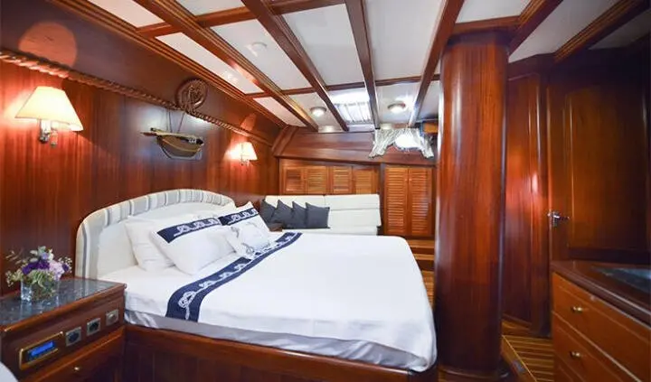 Master cabin with two large beds and wooden cabinets on Ros Mare