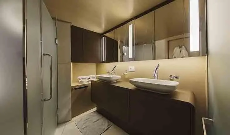 Omnia master cabin with king bed, en suite and dark wood cabinetry