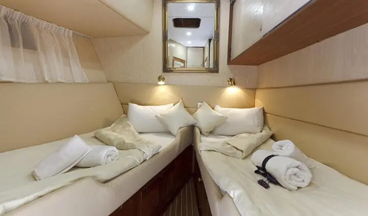 Twin cabin on Aborda yacht with two single beds and porthole window
