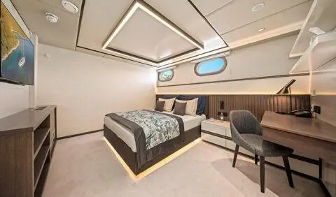 Master cabin with king bed, patterned bedding, and built-in ensuite area