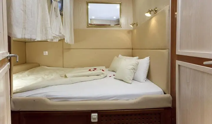 Master cabin with king bed, white bedding, beige walls, and pillows