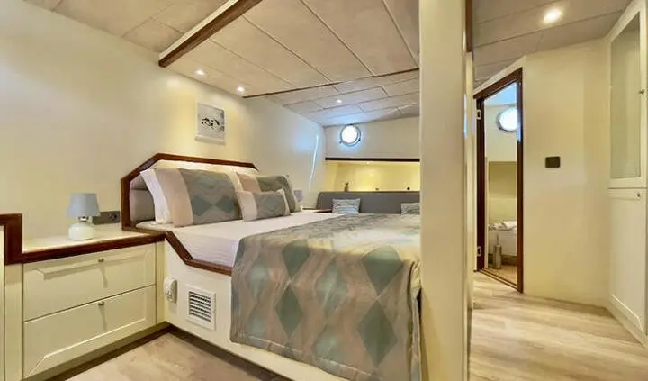 Master cabin with king bed, ensuite, wood paneling and storage lockers