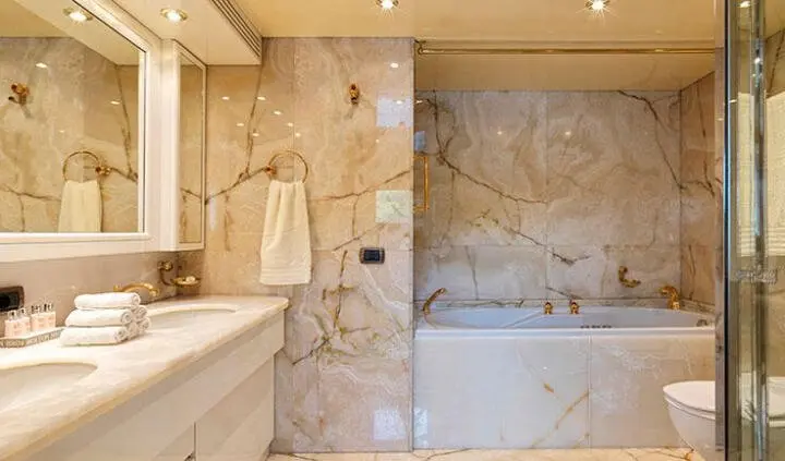 Master cabin with king bed, ensuite bathroom and marble walls aboard Idylle