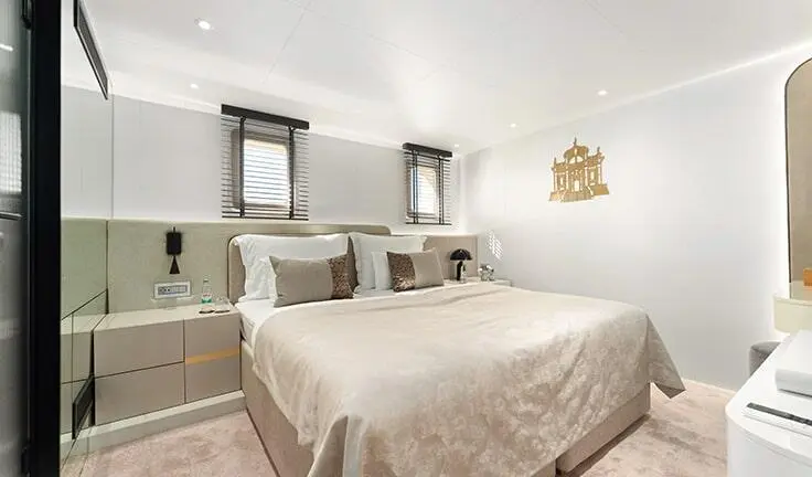 Master cabin with king bed, beige linens, nightstands, and ensuite doorway
