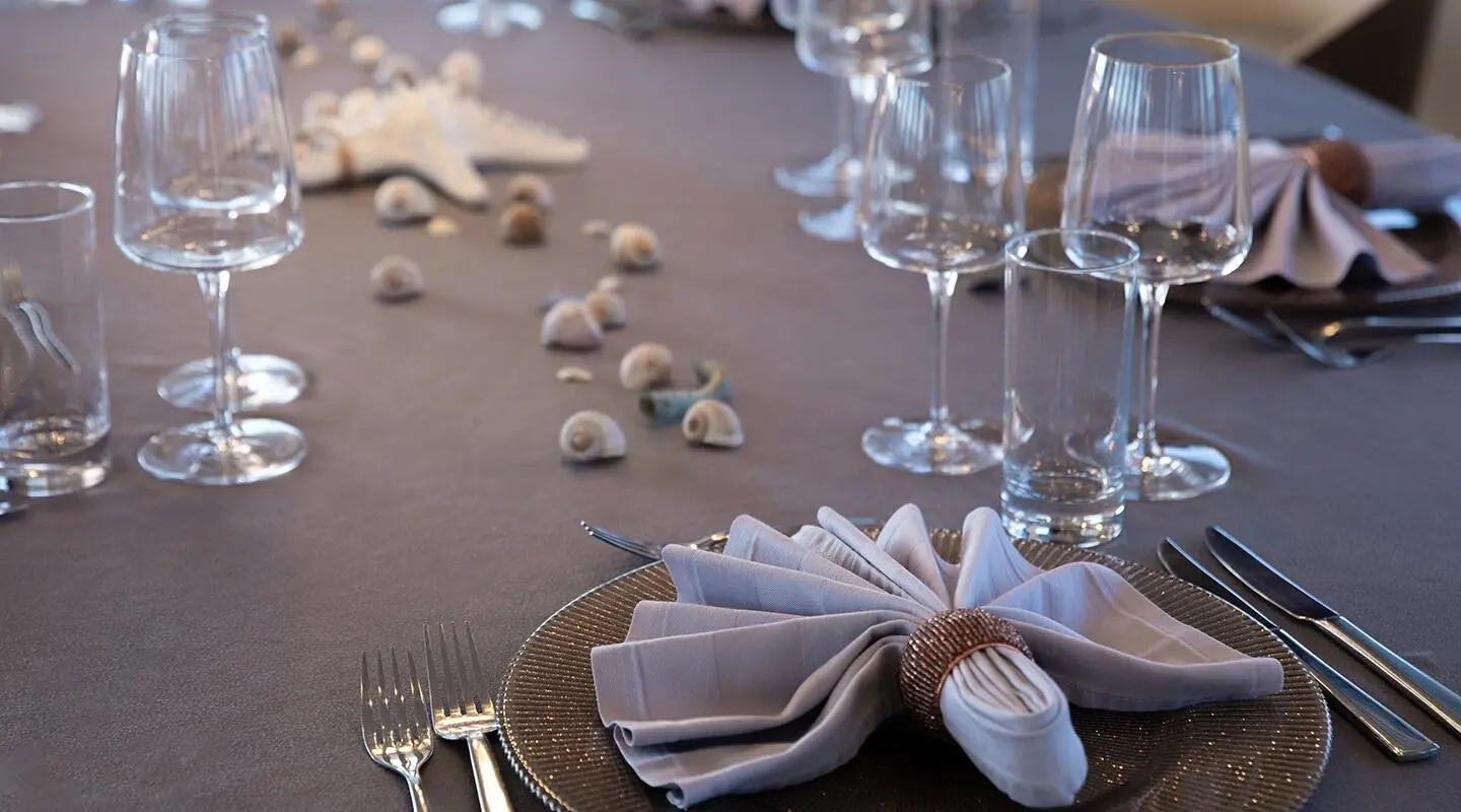 Table set for a yacht charter with folded napkin, wine glasses and cutlery