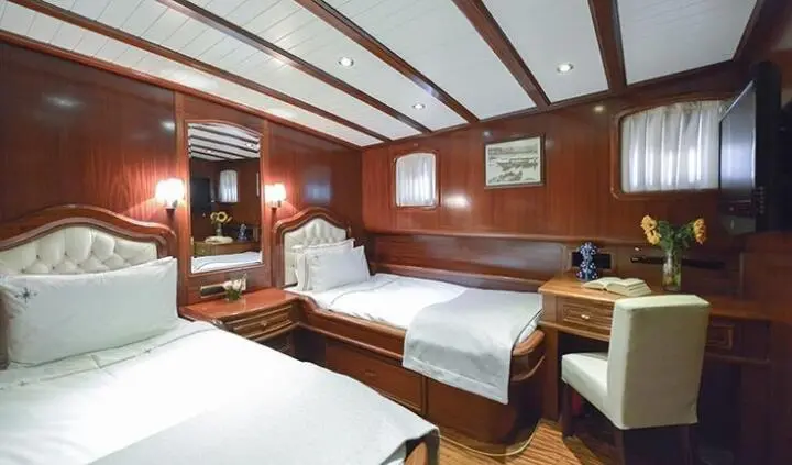 Twin cabin aboard Lady Christa yacht with wooden interior and two beds