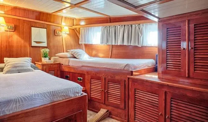 Interior of Just Marie 2 cabin with wooden bunks and curtains