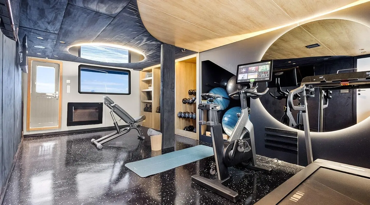 Interior of Bella yacht with seating area, wooden accents, and gym equipment