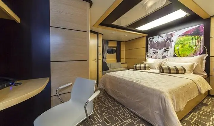 Navilux master cabin with king bed, bedside lamps, and seating area