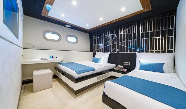 Master cabin with king bed, ensuite, blue and white bedding, wood accents