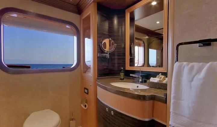 Meira yacht master cabin with king bed and ensuite visible windows and wood cabinetry
