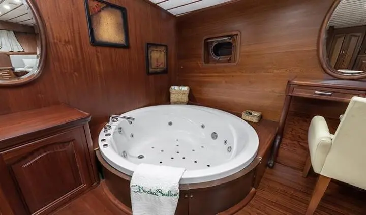 Master cabin on Bedia Sultan with a circular Jacuzzi tub and wood paneling