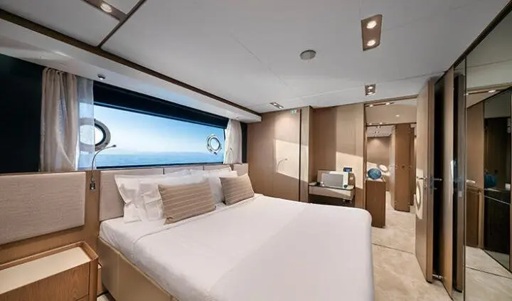 Spica cabin interior with king bed, neutral tones, window view, seating area