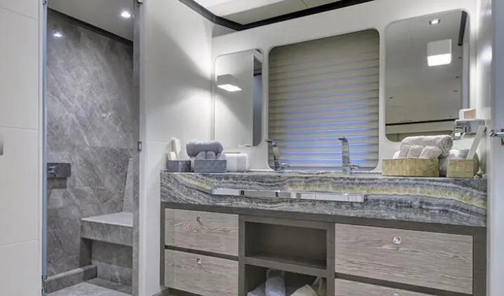 Master cabin with king bed and ensuite bathroom, neutral tones, storage drawers