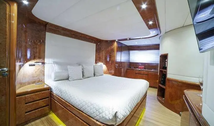 Bedroom on Zoi yacht cabin with large bed, white linens, wood accents
