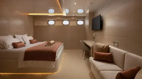 Love Story yacht interior with bed, seating area, warm lighting, and TV