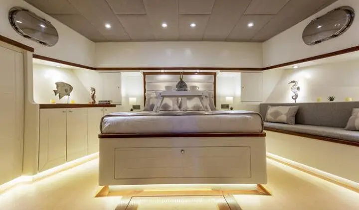 Master cabin with king bed, ensuite, upscale wood paneling and soft lighting