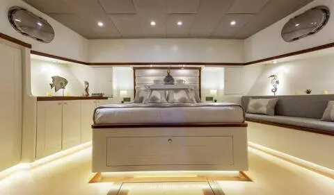Master cabin with king bed, ensuite, upscale wood paneling and soft lighting
