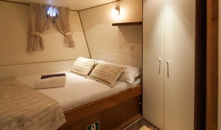 Romanca yacht cabin with double bed and wooden built-in wardrobes