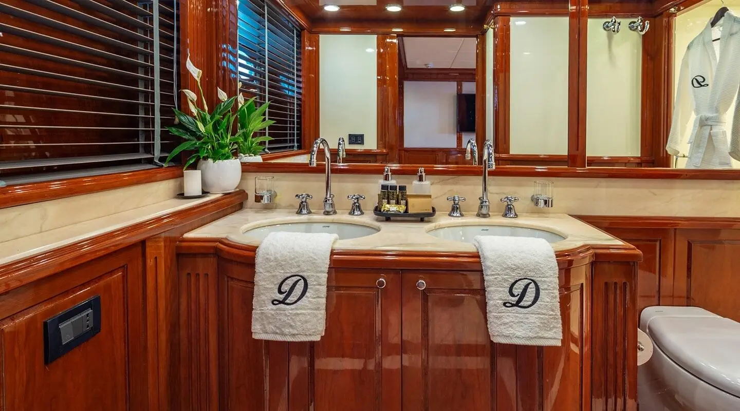 A luxurious yacht deck scene with polished wood, seating, and towels draped over benches