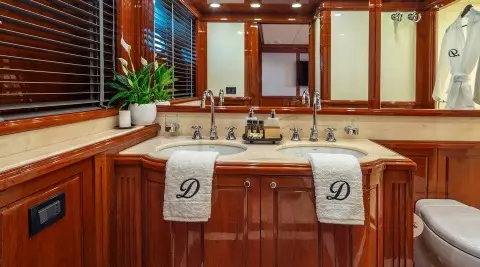 A luxurious yacht deck scene with polished wood, seating, and towels draped over benches