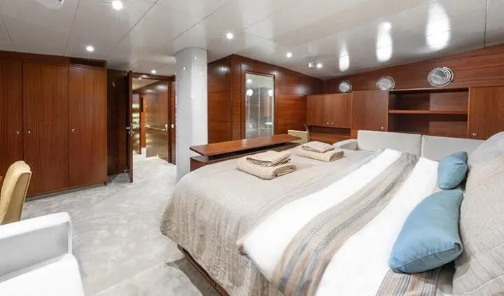 Luxurious master cabin with two single beds pushed together and ensuite visible