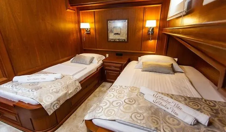 Dolce Vita yacht twin cabin with two single beds and wooden walls