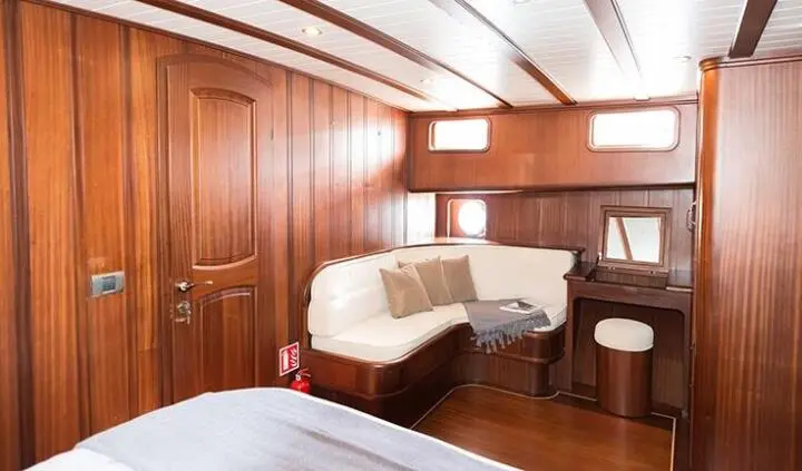 Master cabin with king bed, wood-paneled walls, and ensuite bath on Primadonna yacht