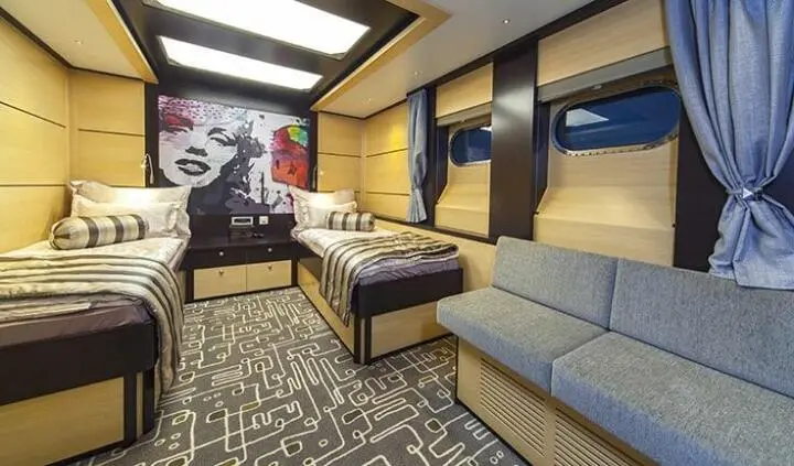 Navilux yacht cabin interior with bed, seating, and wood finish