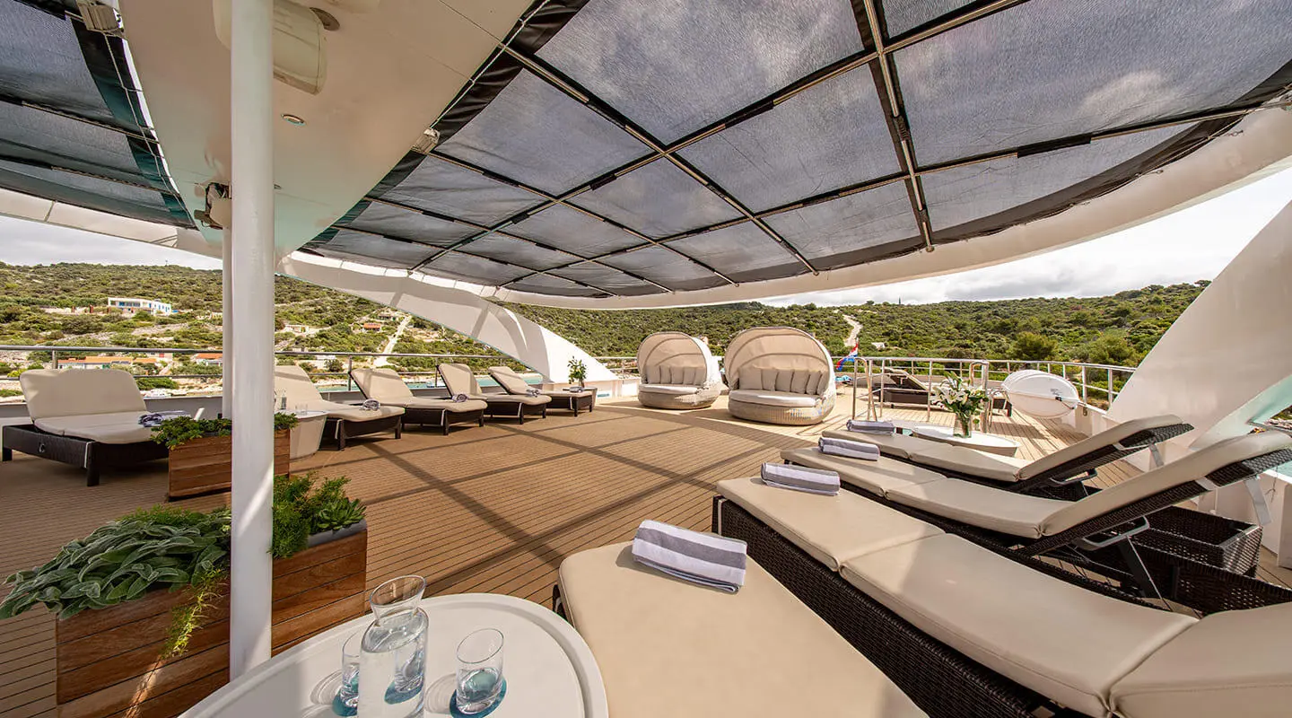 Karizma motor yacht sundeck with seating, sun loungers, and shaded area