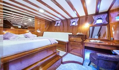 Stella Maris master cabin interior with wood louvered ceiling and bed