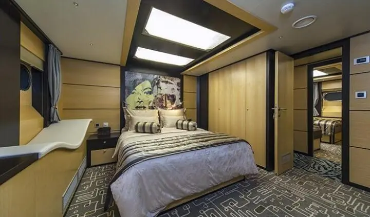Navilux yacht cabin interior with plush bed, wooden panels, and contemporary decor