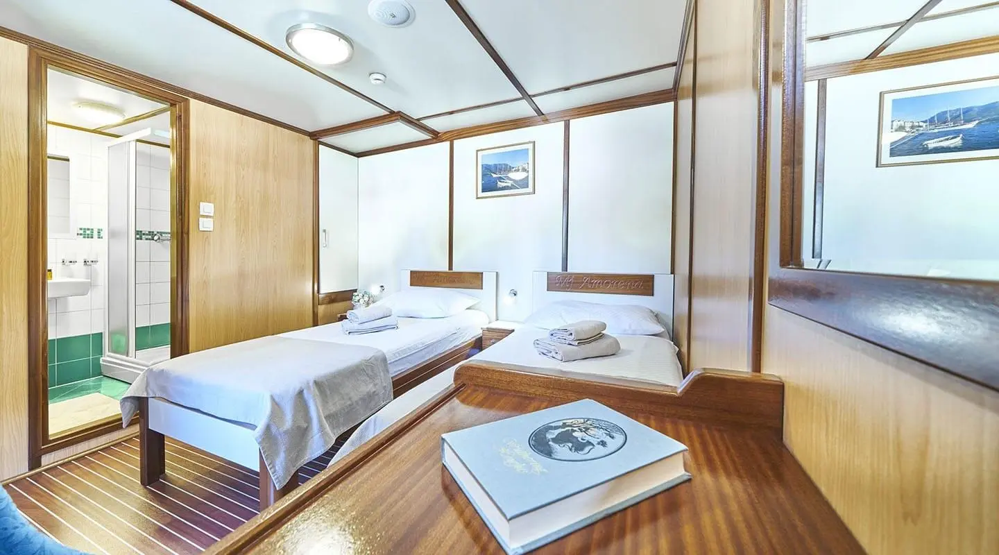 Luxurious Amorena yacht deck with sun loungers, polished wood, and seating area