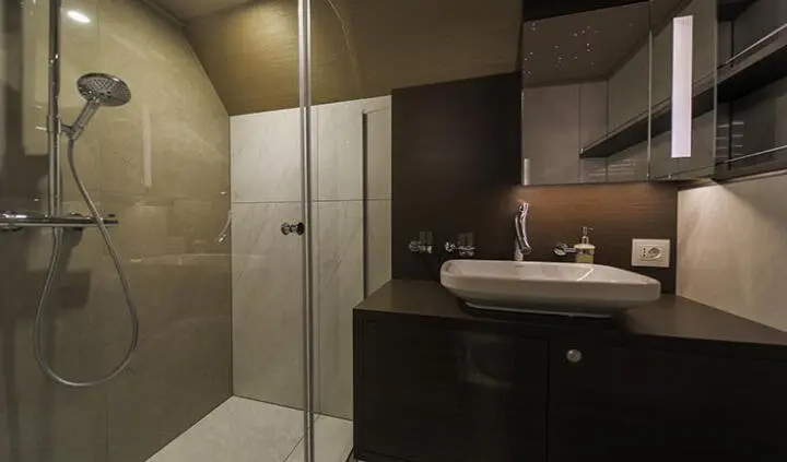Omnia yacht master cabin with king bed, ensuite bathroom and dark wood cabinetry